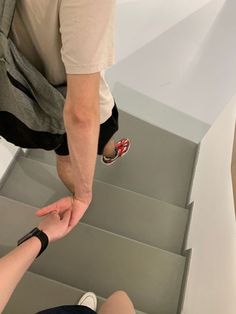 two people sitting on the stairs with their feet in each other's hands,