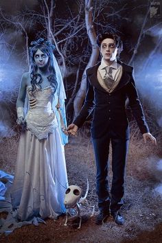 a man and woman dressed up as corpse bride and groom holding hands in the woods