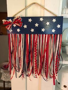 an american flag hanging on a door with red, white and blue ribbons attached to it