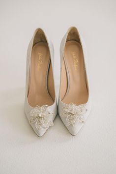 a pair of white shoes with bows on them