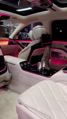 the interior of a luxury car with pink accents