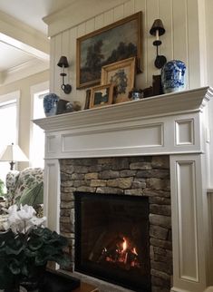 a living room with a fire place and pictures on the fireplace mantel above it