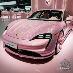 a pink sports car is on display at an auto show