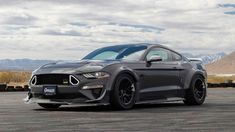 a gray mustang parked in an empty parking lot