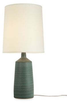 a table lamp with a white shade on the base and a cord attached to it