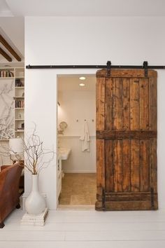 the interior of a house with white walls and wood doors that are open to reveal a living room