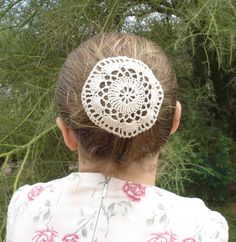 the back of a woman's head with a crocheted hair piece