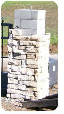 an outdoor fire place made out of bricks and concrete blocks, sitting on the side of a road