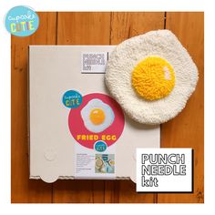 an egg on top of a cardboard box next to a sticker with the word fried egg