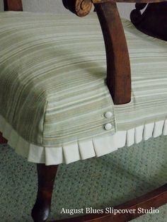 an upholstered rocking chair with buttons and pleated fabric on the seat cushion