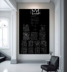 a large black and white poster hanging on the wall above a chair in a room