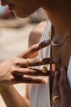 a close up of a person wearing rings and necklaces