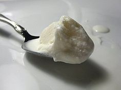 a spoon filled with ice cream on top of a white plate