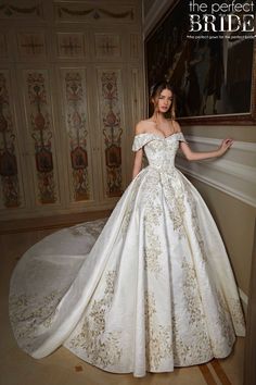 a woman in a wedding dress leaning against a wall with her hand on the shoulder