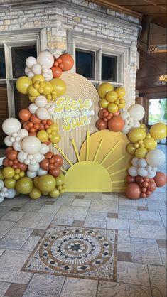 an arch made out of balloons with the words gen's sun on it in front of a building