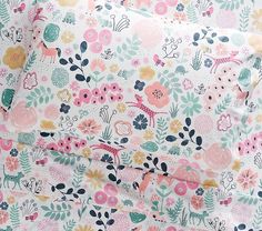 a close up of a flowered bed sheet and pillowcase with animals on it