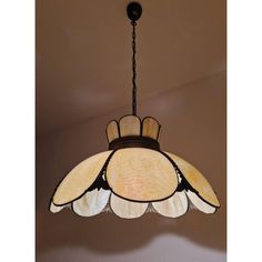 a light fixture hanging from the ceiling in a room with white walls and brown trim