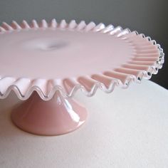 a pink cake plate sitting on top of a table