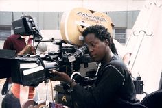 a woman sitting in front of a movie camera