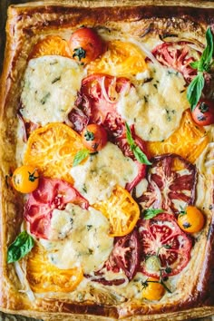 a square pizza with tomatoes, cheese and basil on the top is ready to be eaten