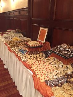 a long table covered with lots of different types of food and pastries on it