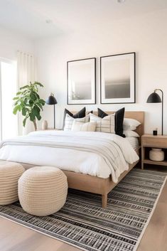 a bedroom with white bedding, black and white decor and pictures on the wall