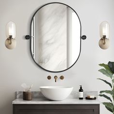 a bathroom sink sitting under a round mirror next to a wall mounted faucet