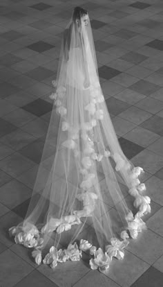 a woman in a wedding dress standing on the floor with her veil over her head