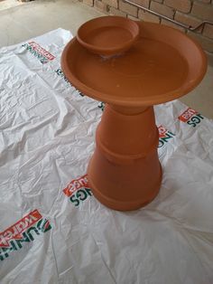 a large clay bowl sitting on top of a table covered in white plastic wrappers