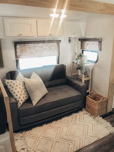 a living room with a couch, rug and window in the back ground is shown