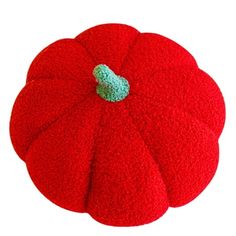 a red round cushion with a green patch on the top and bottom, sitting in front of a white background