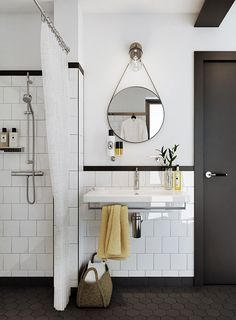 a white bathroom with black and white tile on the floor, sink, mirror and shower