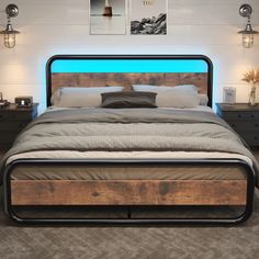 a bed that has some lights on the headboard and side tables in front of it