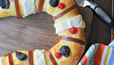 a homemade fruit and cheese wreath on a wooden table