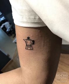 a small coffee pot tattoo on the arm