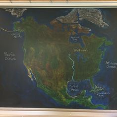 a chalkboard map of the united states with rivers and lakes on it, in front of a wooden frame