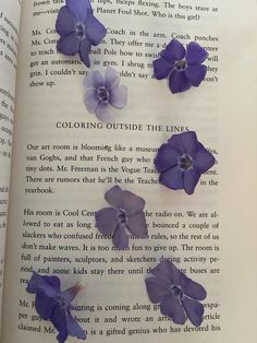 an open book with purple flowers on it