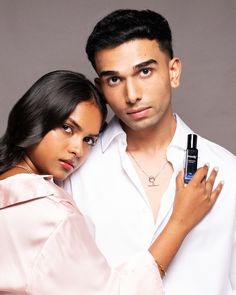 a man and woman are posing for a photo with a cell phone in their hand