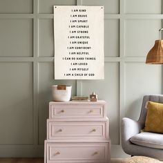 a pink dresser sitting next to a gray chair