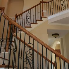 a staircase with wrought iron handrails and wood balconies in a home