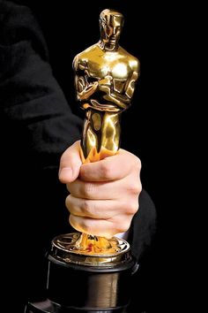 a person holding an oscar statue in their hand