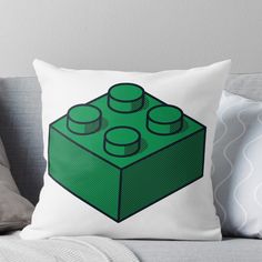 a green lego block pillow on a couch