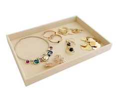 a white tray with various jewelry on it