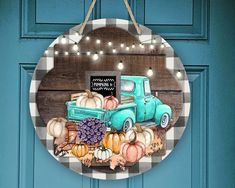 a blue truck with pumpkins and gourds hanging on a door