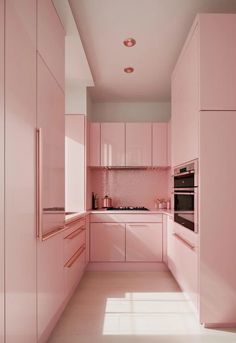 a kitchen with pink cabinets and white counter tops