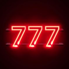 a red neon sign with the number seventy7 on it's side in front of a black background