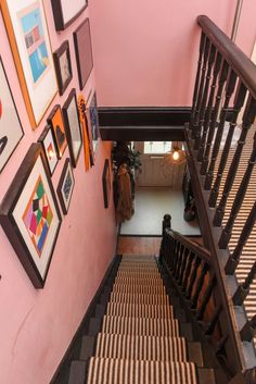 an overhead view of a staircase with pictures on the wall and carpeted flooring