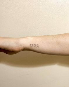 a woman's arm with two hearts on it and the word love written in black ink