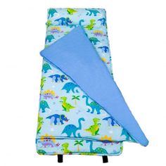 a blue blanket with dinosaurs on it and a light blue cover over the top of it