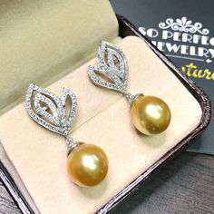 We are presenting you A PAIR OF matching SOUTH SEA PEARLS with LUSTROUS GOLDEN color. SET IN HANDCRAFTED, 18K SOLID GOLD DROP EARRINGS. ACCENTED WITH 116 E/VS, SPARKLING ROUND BRILLIANT DIAMONDS! IN CASE OF RETURN FOR US BUYERS. BUYERS MAY SEND THE ITEMS BACK TO OUR US-BASED OFFICE IN SALT LAKE CITY, UTAH ONLY ONE ITEM AVAILABLE!! NO DUPLICATES!! WHAT YOU SEE IN THE PICTURES IS WHAT YOU WILL GET SOLIDLY HANDCRAFTED EARRINGS! SUGGESTED RETAIL VALUE: $9,880 PEARLS: Size: 12 x 11 mm Shape: Oval/Rou Luxury Yellow Earrings For Wedding, Luxury Pear-shaped Bridal Earrings For Party, Yellow Gold Drop Bridal Earrings For Formal Occasions, Formal Yellow Gold Drop Bridal Earrings, Gold Diamond Pearl Earrings For Wedding, Luxury Yellow Gold Teardrop Bridal Earrings, Luxury Pearl Drop Earrings For Anniversary, Luxury Drop Pearl Earrings For Anniversary, Luxury Gold Teardrop Bridal Earrings